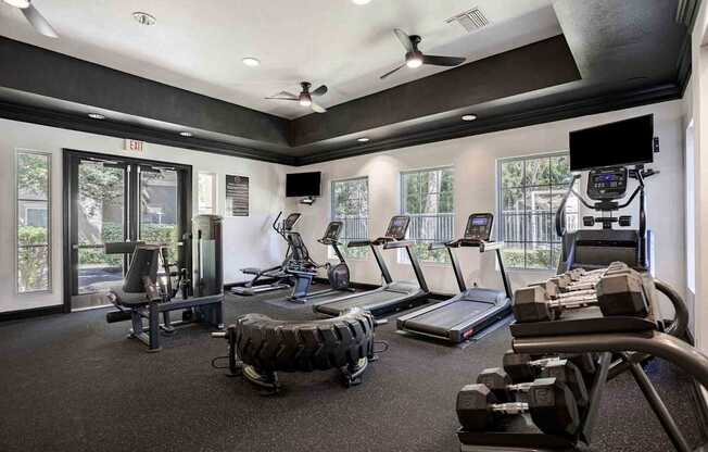 A gym with treadmills, weights, and exercise equipment.