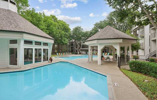 A swimming pool with a pavilion and a person walking.