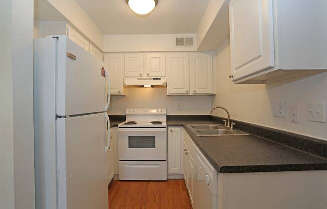 A kitchen with white appliances and cabinets.