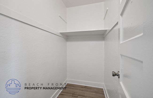 a walk in closet with white walls and a white door