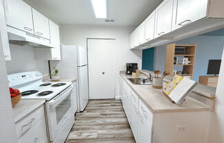 a kitchen with white appliances and white cabinets