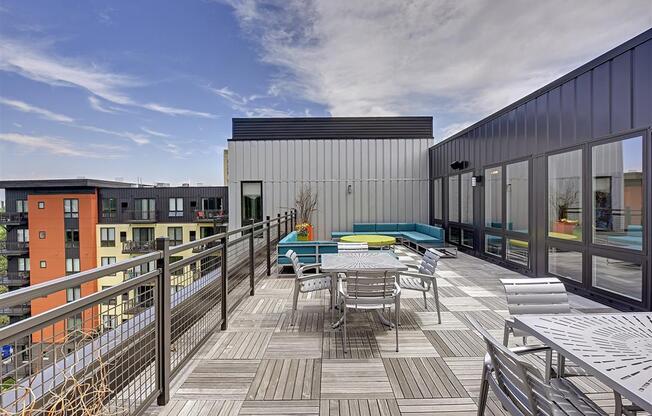 Be @ Axon Green Rooftop Patio with tables, chairs, and couches