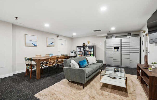 A living room with a grey couch, a wooden table, and a rug.