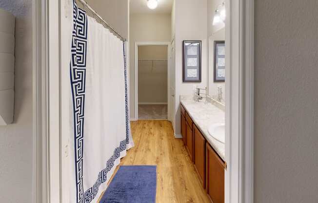 a bathroom with a white and blue shower curtain