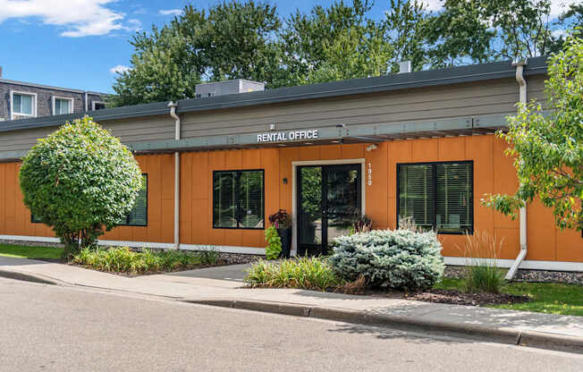 A rental office building with a green lawn in front.