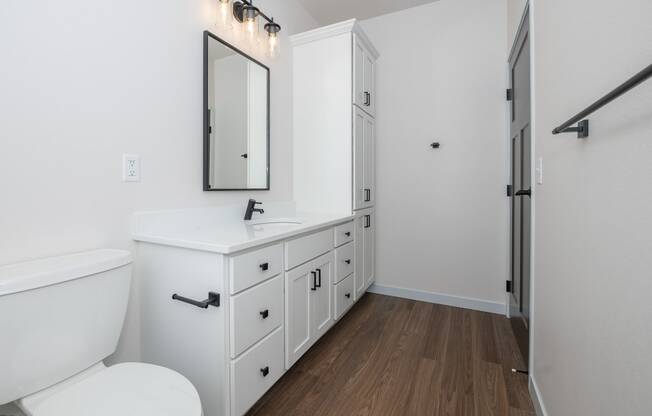 a bathroom with white cabinets and a white toilet and sink at The Crossings at Windsong, Prescott Valley