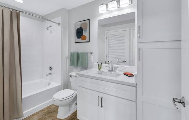 a white bathroom with a shower and a sink and a toilet