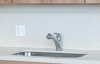 a kitchen counter with a sink and wooden cabinets