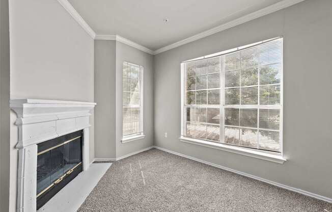 A room with a fireplace and a window with blinds.