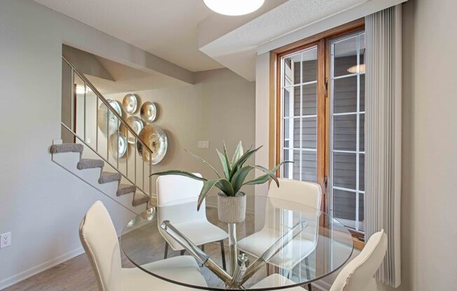 a dining room with a glass table and chairs