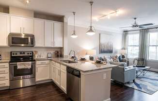 A modern kitchen with a large island and a dining area.