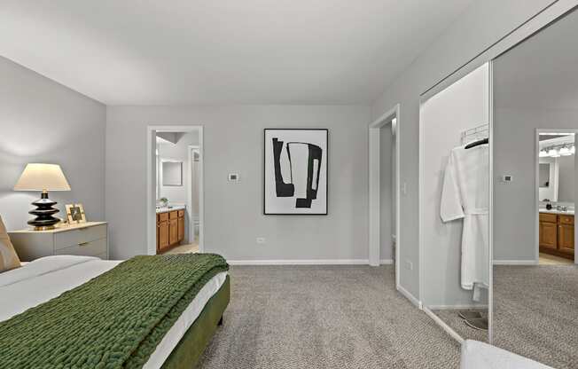 A bedroom with a green bedspread and a large painting on the wall.