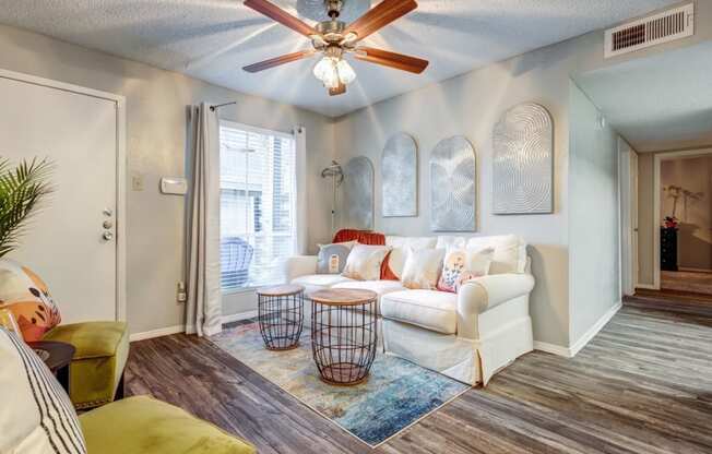 a living room with a white couch and a ceiling fan