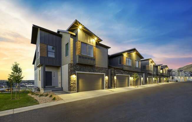 a row of houses with lights on at dusk