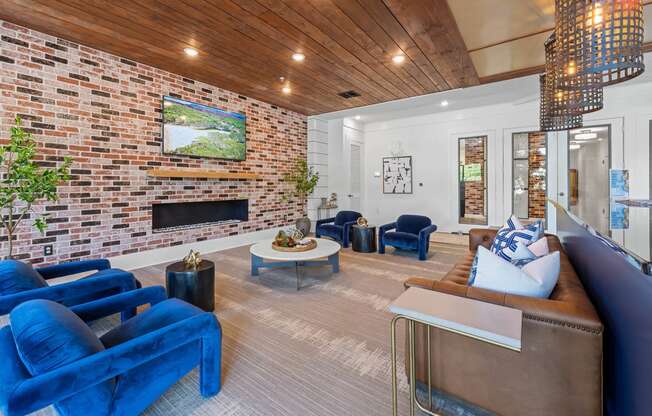 a living room with blue furniture and a brick fireplace