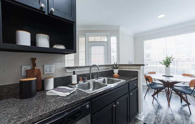 kitchen with black cabinetry and granite-style countertops