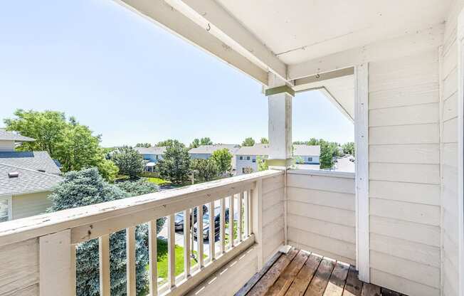 Patio with Wood Raining Overlooking Trees and Buildings
