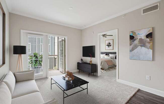 A living room with a white couch, a black coffee table, and a painting on the wall.