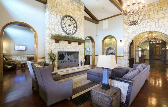 A living room with a stone wall and a large clock.