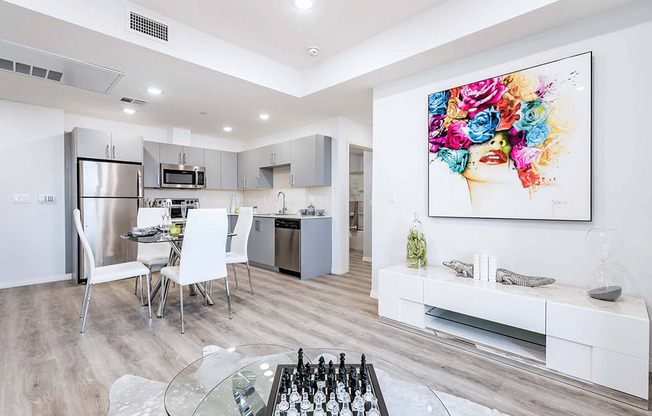 Modern interior of a unit with stainless steel appliances, laminate flooring throughout, recessed lighting