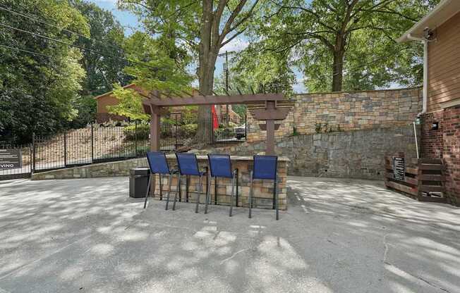 A patio with a table and chairs under a pergola.