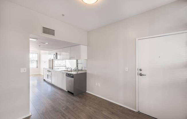 A kitchen with white cabinets and a white door.