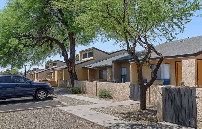 a blue car parked in front of a row of houses