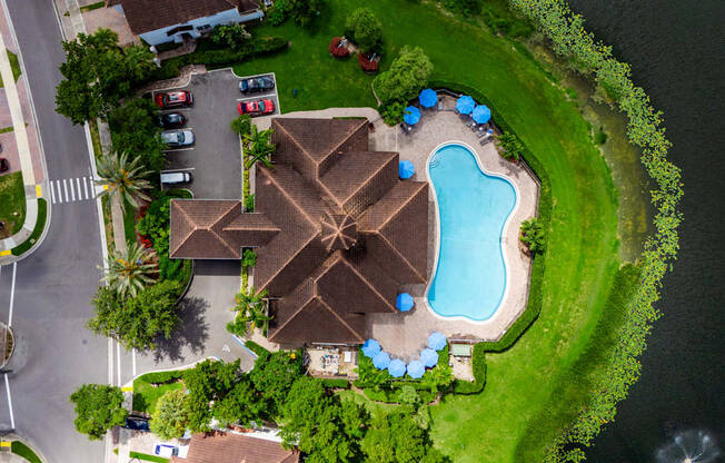 A swimming pool surrounded by a grassy area and a few trees.