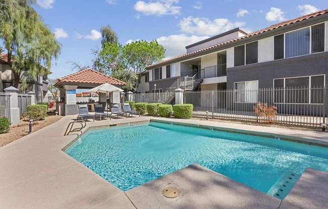 A swimming pool in a residential area with a building in the background.