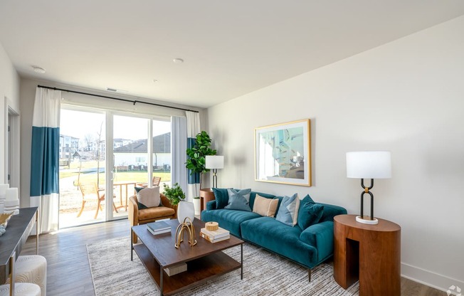 a living room with a blue couch and a sliding glass door at Fairmont at South Lake, Bowie, 20716
