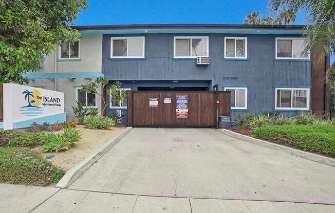 The Island Apartments is a blue building with a sign in front.