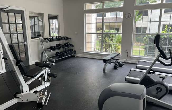 a gym with weights and other exercise equipment and windows