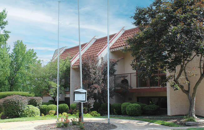 a building with two flag poles and a sign in front of it