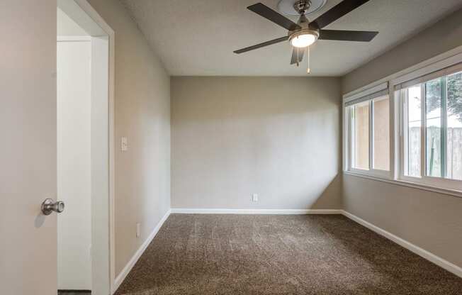 a bedroom with a ceiling fan and a window