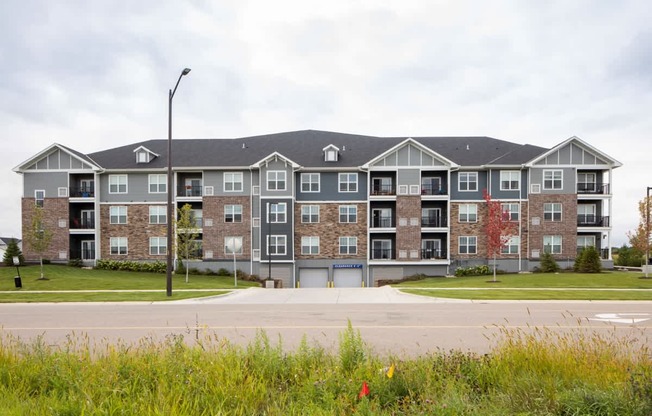 A large apartment complex with a grassy area in front.