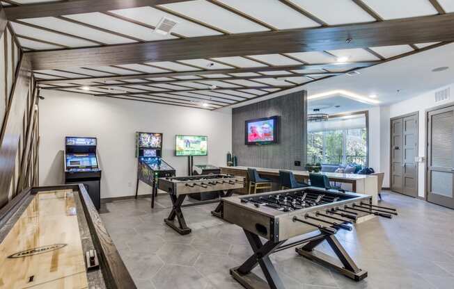 a game room with a foosball table and two game systems