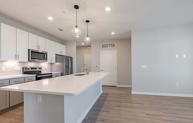 an empty kitchen with a large white counter top