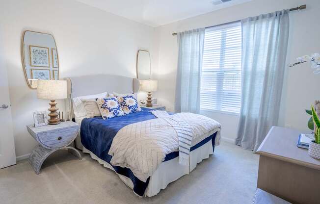 A bedroom with a large bed and a mirror on the wall.