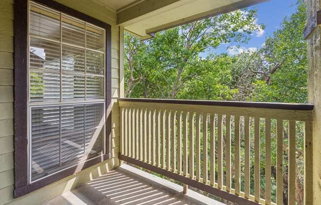 A view from a balcony with a window and a railing.
