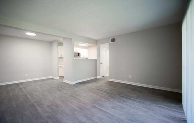 the living room and kitchen of an empty house