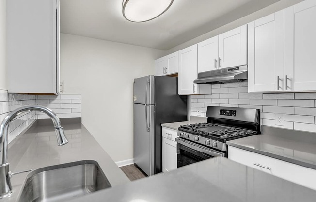 A kitchen with a refrigerator, stove, and oven in loft apartment at Ledges Apartments.