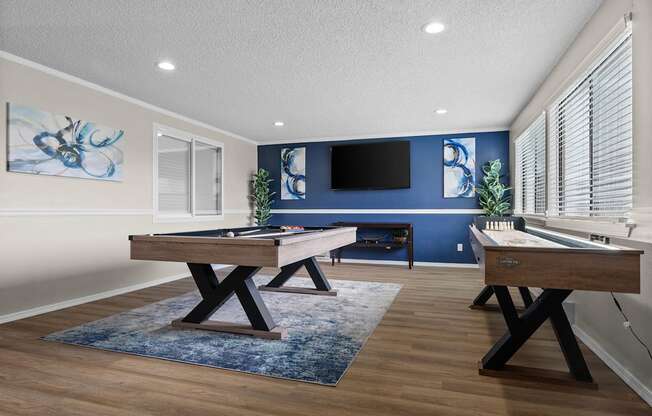 A room with a pool table and a TV mounted on the wall.