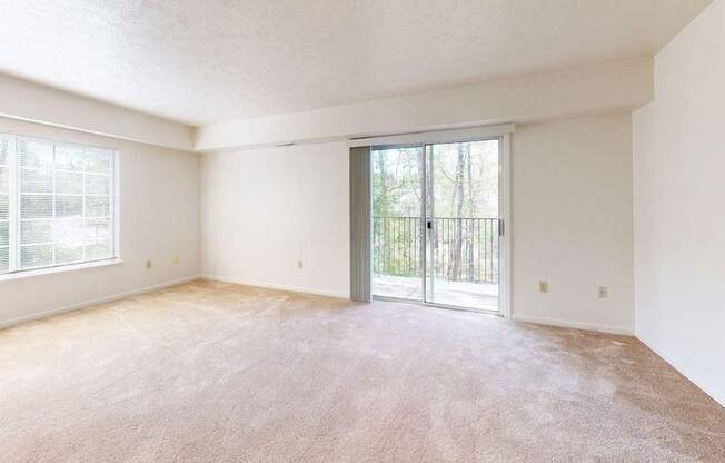 an end living room with a sliding glass door to a balcony at Fieldstream Apartment Homes, Iowa