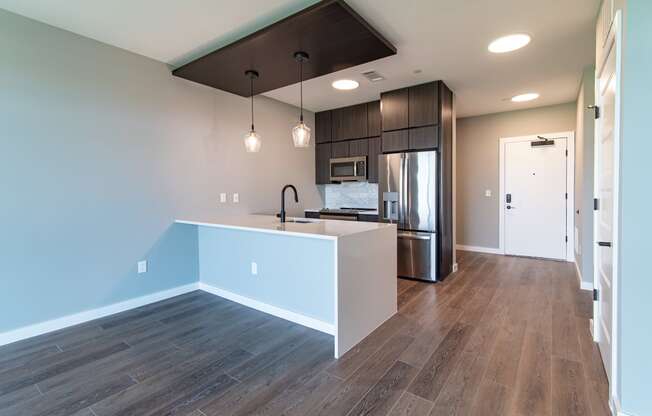 a kitchen with a white island and a stainless steel refrigerator