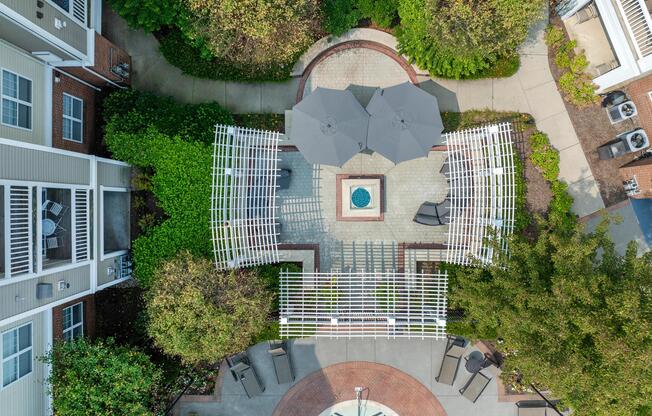 Aerial view of the courtyard retreat highlights pergola-covered seating, a central fire feature, and landscaped gathering spaces.