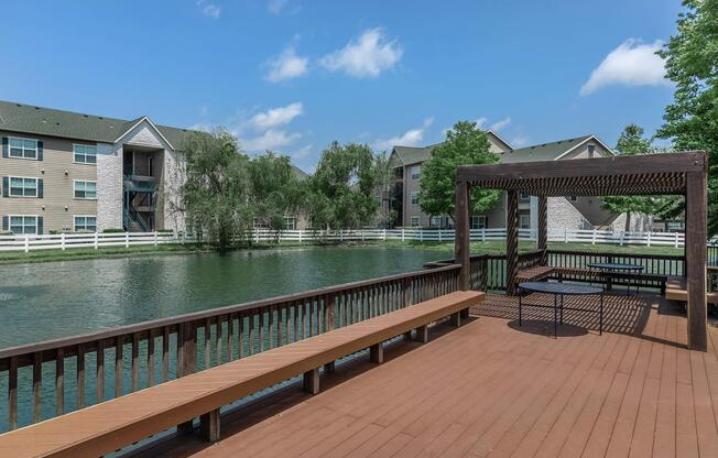 a wooden bench sitting next to a pool of water