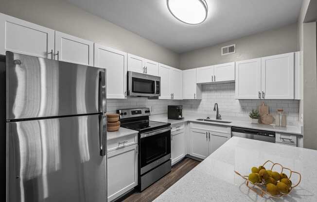 a kitchen with white cabinets and stainless steel appliances