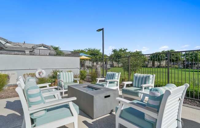 furnished patio with blue and white chairs and a firepit