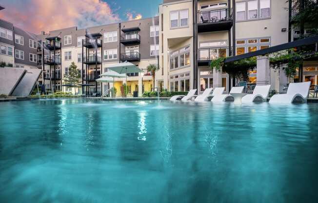 an image of an apartment building with a large pool in the foreground