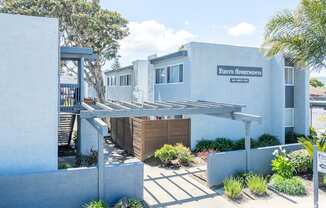 A white building with a sign that says "Fresh Apartments".
